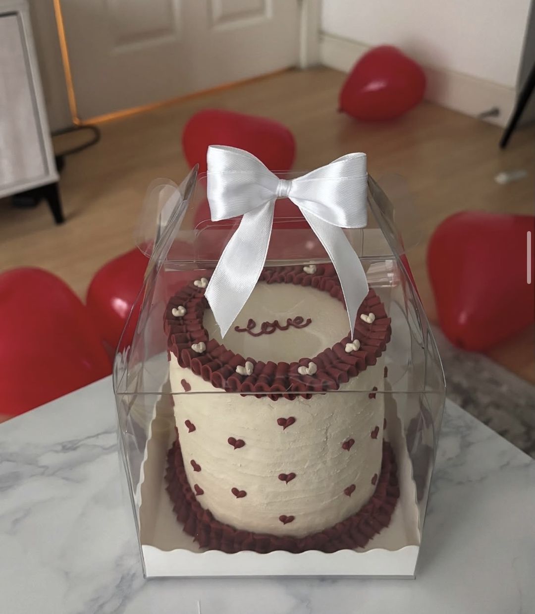 Cream bento cake with burgundy ruffles, tiny piped hearts and “love” on top, tied with a white bow (photo 1 of 2)
