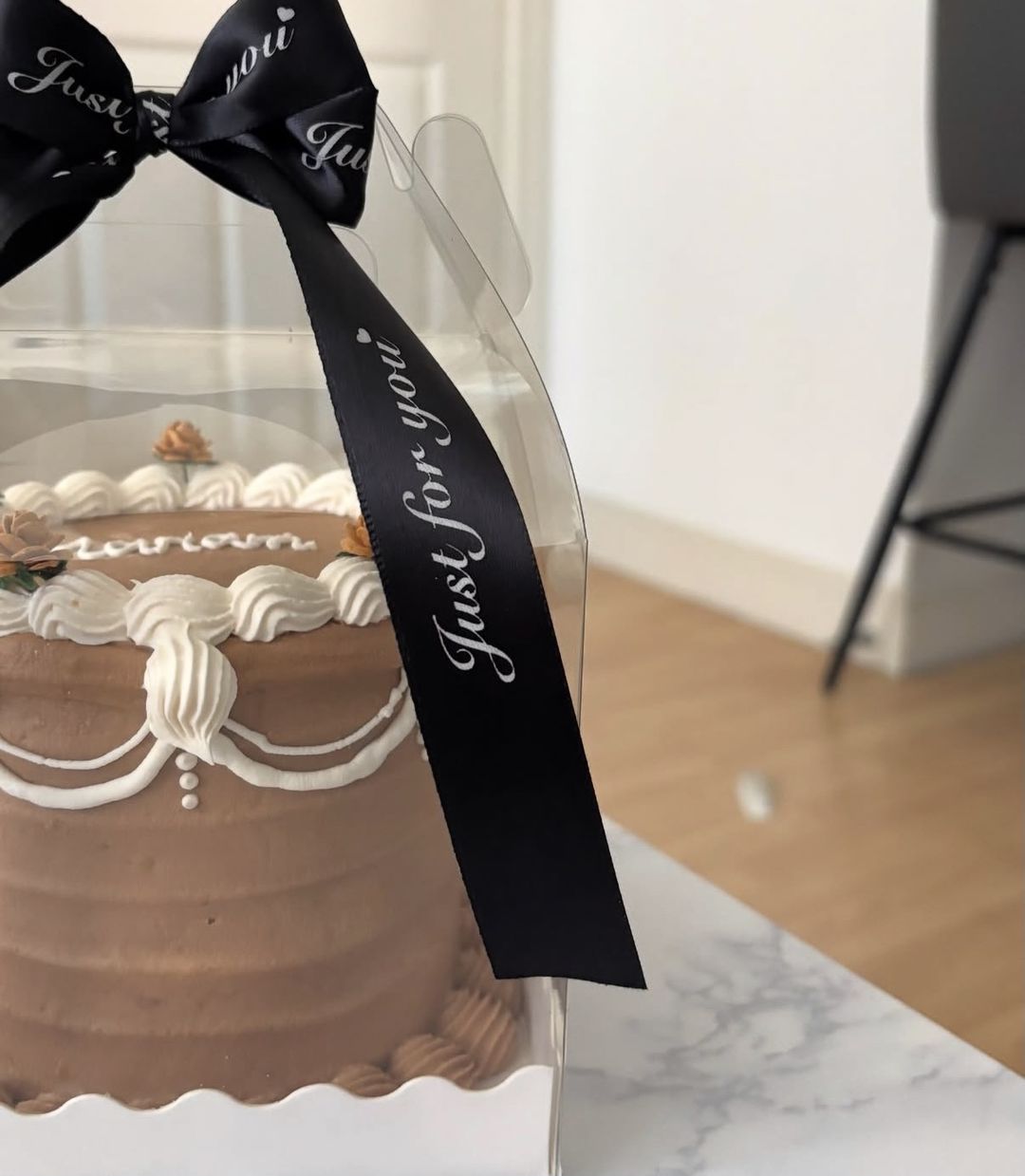 Chocolate-brown vintage bento with white piped garlands and “Mariam” on top, tied with a black ribbon (photo 2 of 2)