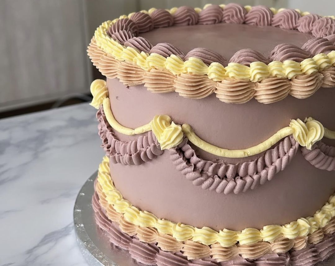 Mauve vintage cake with butter-yellow and lilac shell piping and swag garlands (photo 2 of 2)